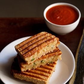 potato sandwich served on a white plate with ketchup in a bowl.