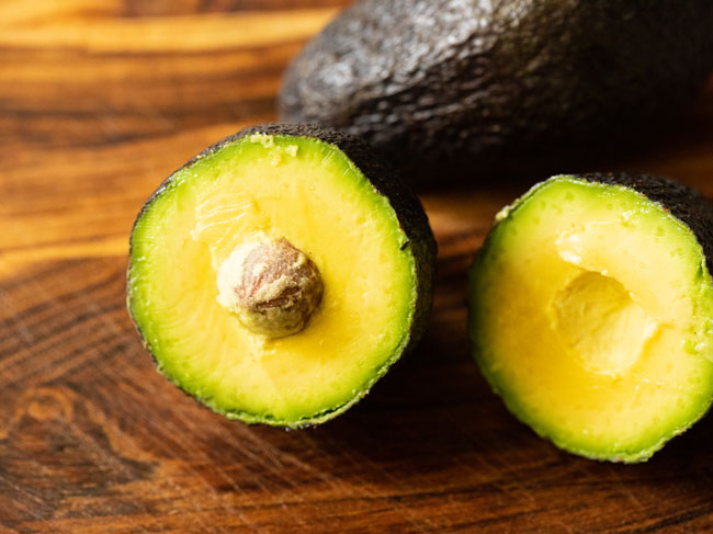 halved avocados on a board.