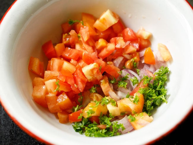 chopped onions, tomatoes and parsley in a mixing bowl.