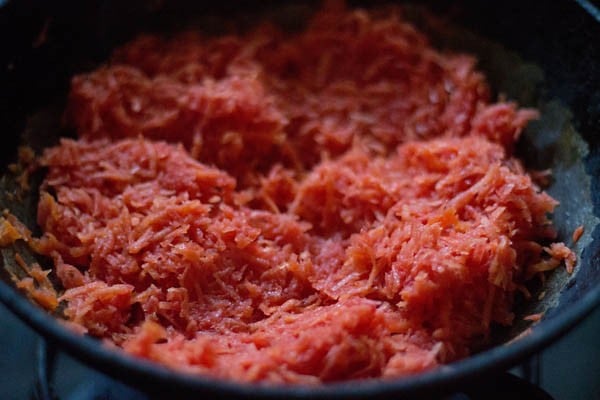 grated carrots in a heavy kadai/wok