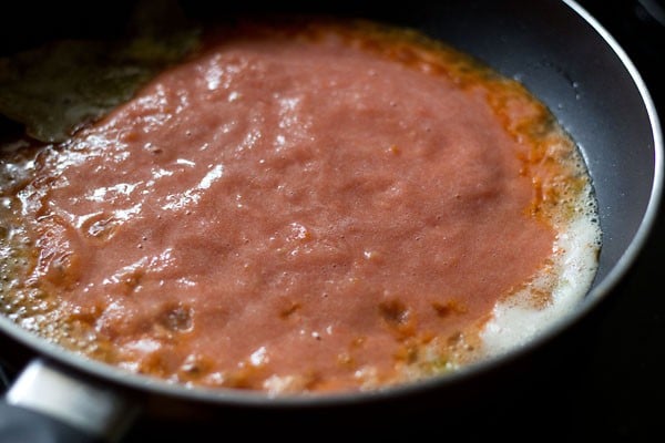 tomato purée added to aromatics for making paneer makhani gravy recipe