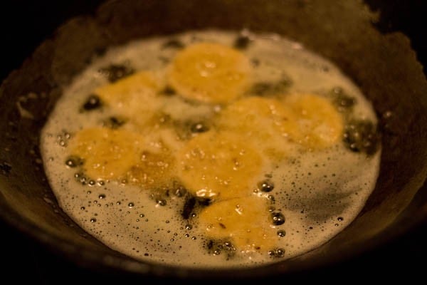 frying papdi in hot oil in kadai. 