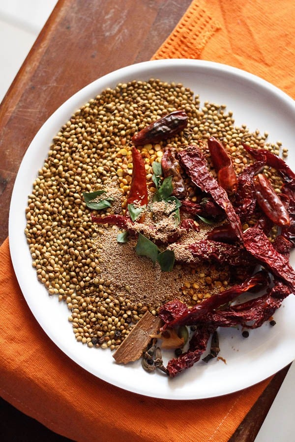 spices kept on a white plate for bisi bele bath powder. 