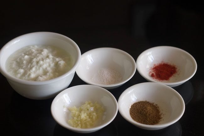 ingredients of burani raita kept in white bowls.