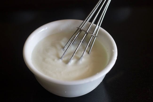 whisking curd in a bowl. 