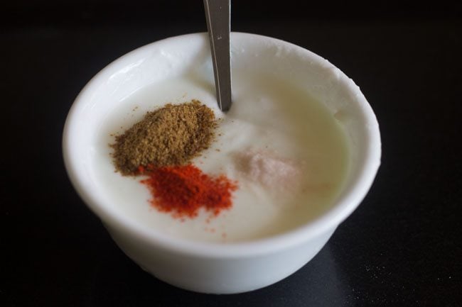spice powders and salt added to whisked curd.