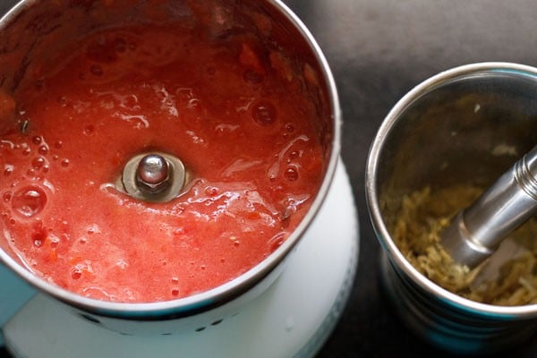 pureeing tomatoes and crushing ginger, garlic into paste 