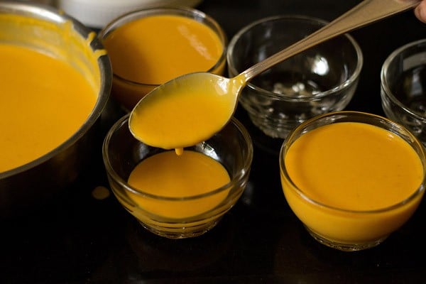 pouring the mango panna cotta into serving bowls.