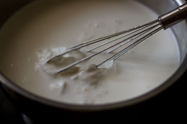 mixing milky panna cotta base ingredients in a saucepan.