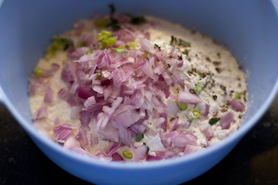 onion rava dosa ingredients added in a bowl. 