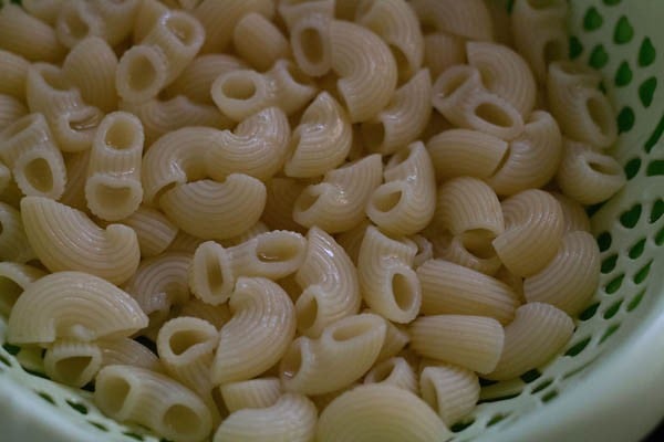 cooked pasta drained in a green colander