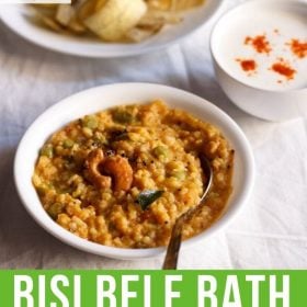 bisi bele bath served in a white bowl with a spoon in it and a bowl of banana chips and small bowl of raita kept in top left and right side and text layovers.