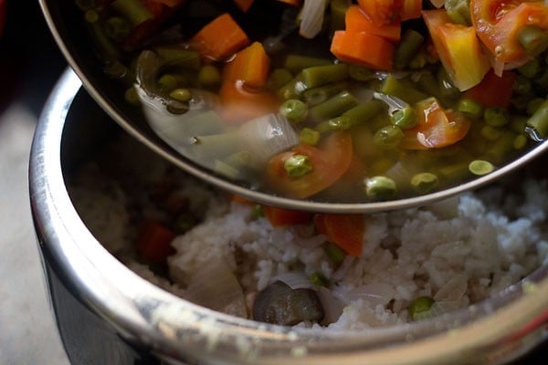 adding cooked vegetables and their stock to the rice, peanuts and lentils. 