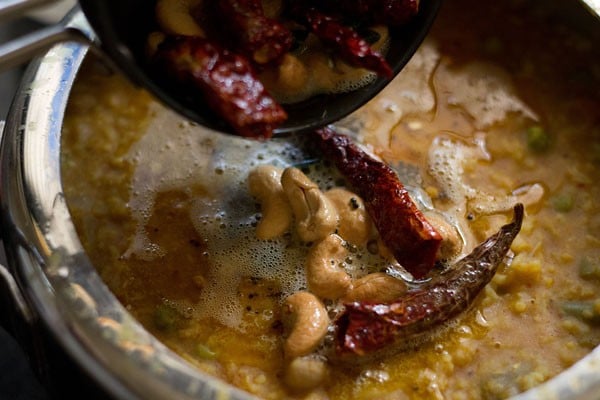 pouring tempering in the prepared bisi bele bath. 