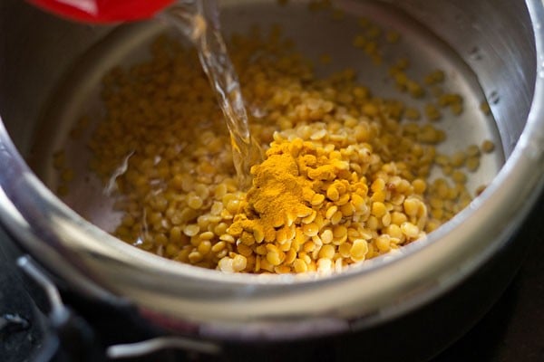 rinsed pigeon pea lentils, turmeric powder and water added in pressure cooker. 