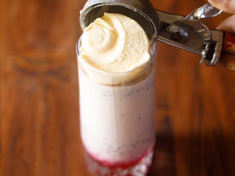 Placing a scoop of vanilla ice cream on top of the glass.