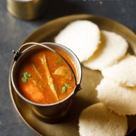 idlis in a plate served with sambar in a bowl