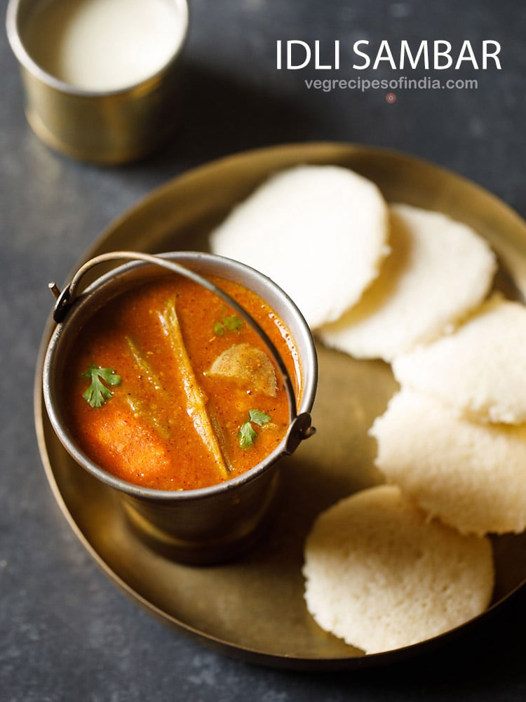 idlis in a plate served with sambar in a bowl