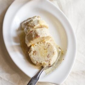 sliced kulfi with a spoon on a white plate