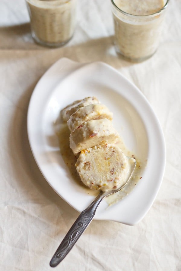 sliced kulfi with a spoon on a white plate