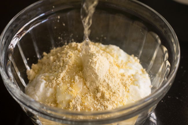 adding water to the curd-gram flour mixture. 