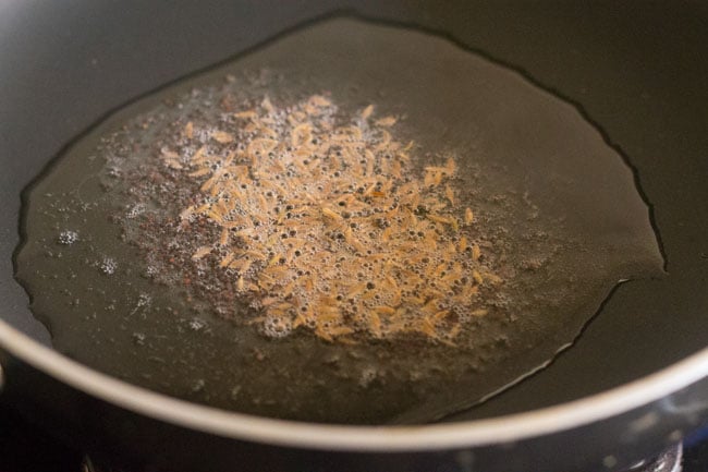 cumin seeds added to the pan. 