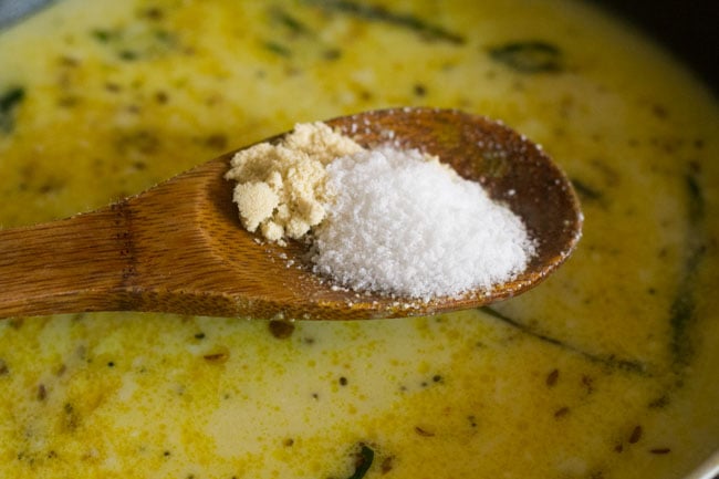 adding salt and sugar to the kadhi mixture. 