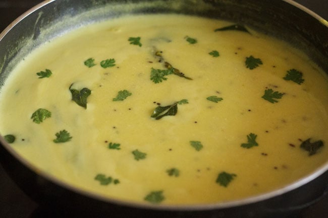 Add chopped coriander leaves to cooked Maharashtrian kadhi. 