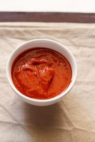 red garlic chutney served in a white bowl.