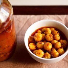 star gooseberry pickle served in a bowl with a pickle jar on the side.