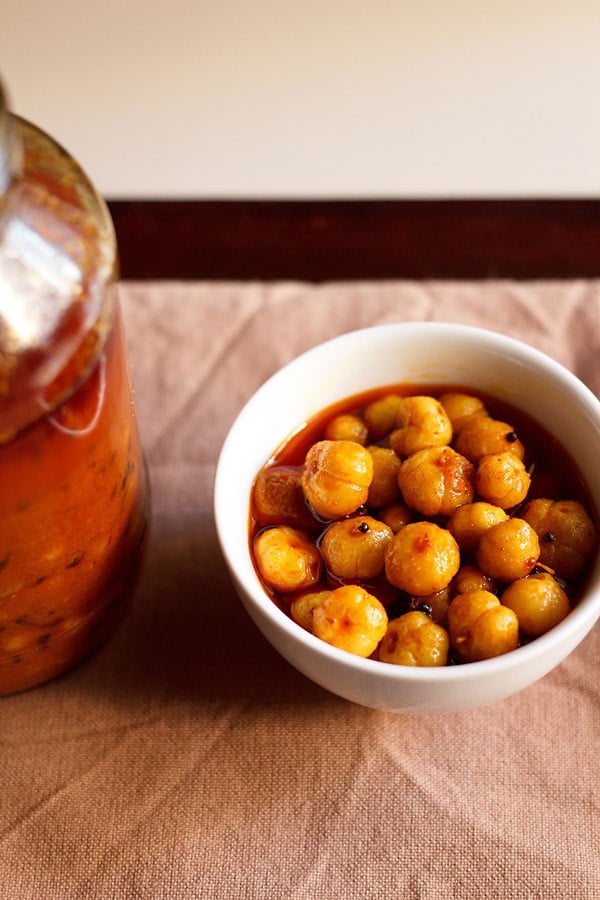 star gooseberry pickle served in a bowl with a pickle jar on the side.