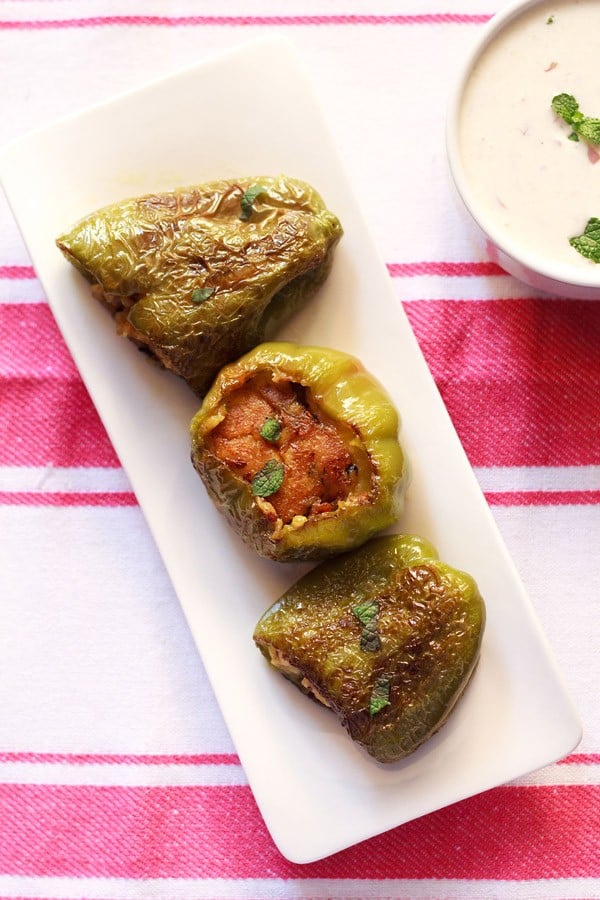 stuffed capsicum served on a long white platter.