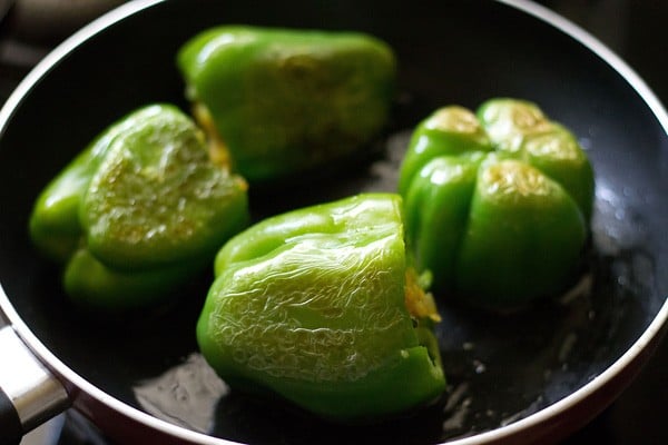 cooking stuffed capsicum in the pan