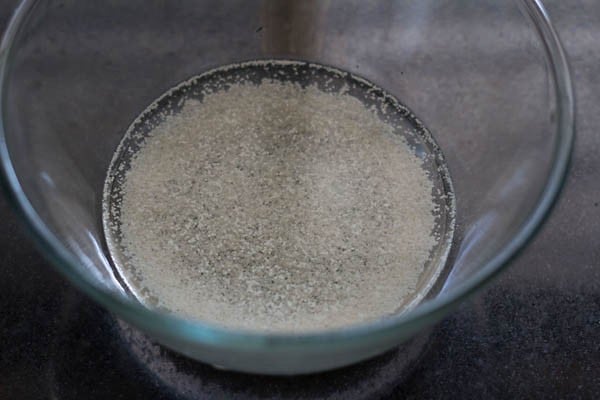 sugar and instant yeast added to warm water in a bowl for making pizza pockets. 