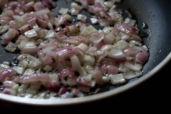 sautéing chopped onions and garlic in hot olive oil in pan for making stuffing for calzone pocket. 