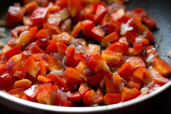 chopped bell peppers added in the pan for making stuffing for calzone pocket. 