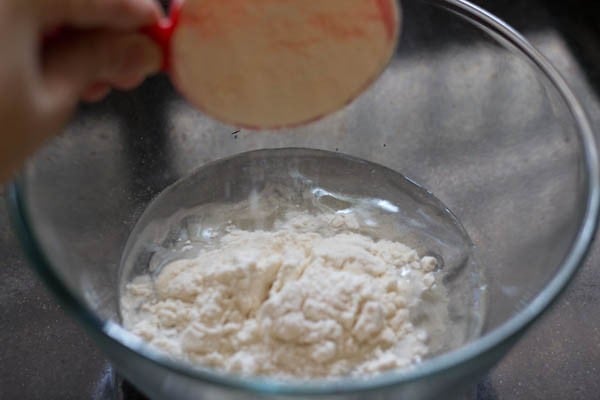 adding all purpose flour to the bowl for making pizza pockets. 
