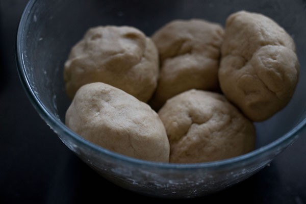 doubled up dough divided in equal balls and placed in a bowl. 