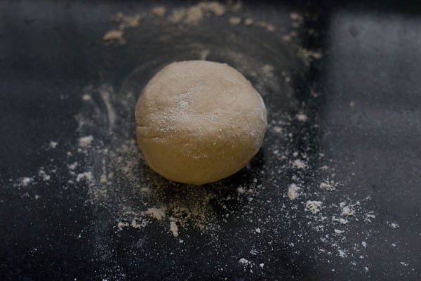 dough ball placed on lightly dusted surface for making calzone pocket. 