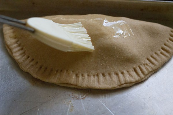 brushing prepared calzone with oil. 