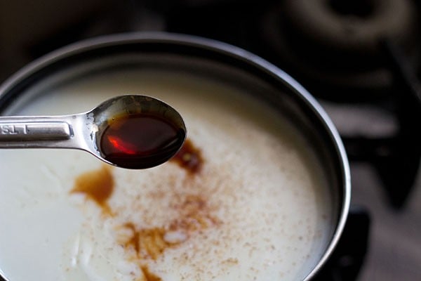 adding nutmeg, vanilla, and cinnamon to custard for flavoring the bread and butter pudding.