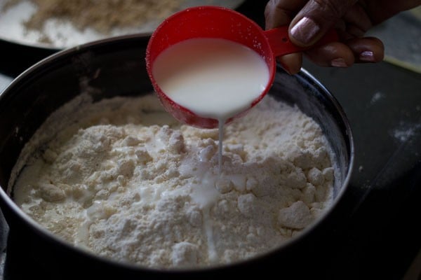 adding milk in parts and begin to knead the dough
