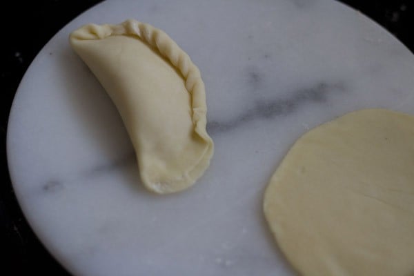 making karanji by pleating and sealing the edges