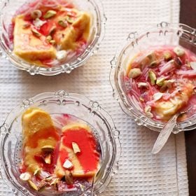 kulfi falooda served in 3 glass bowls with spoons in 2 of them.