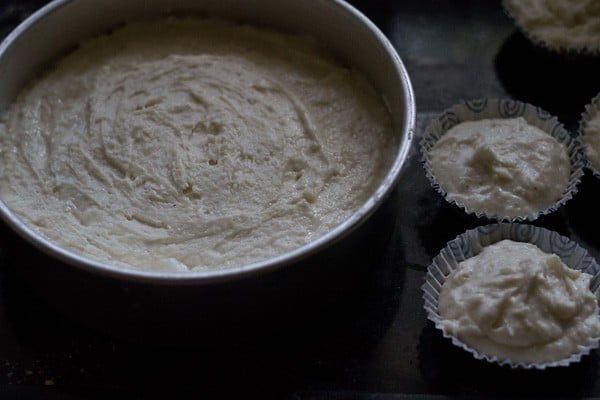 mawa cake batter added to round pan and cupcake liners