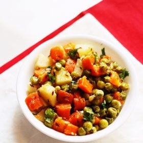 aloo gajar matar served in a white bowl.