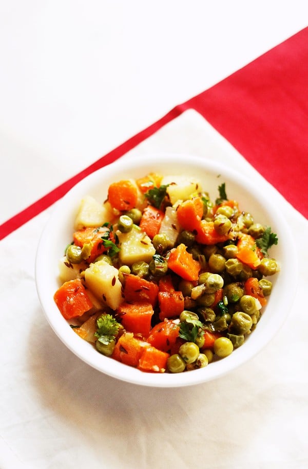 aloo gajar matar served in a white bowl.