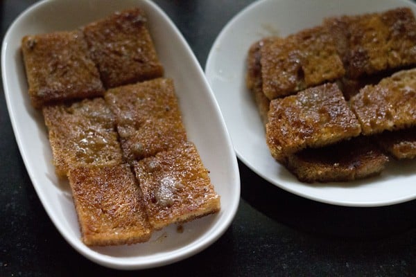 arranging shahi tukra in serving bowls by adding sugar soaked croutons