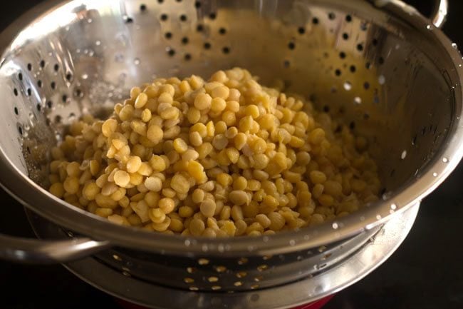 straining pressure cooked chana dal in a colander. 