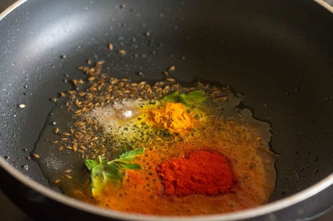 Add curry leaves, turmeric powder, Kashmiri red chilli powder and asafoetida to the pan. 